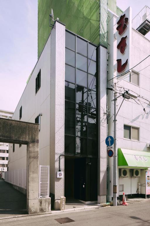 a building with a large glass door on a street at LIFEMENTGLANZ HOTEL Enomachi in Hiroshima