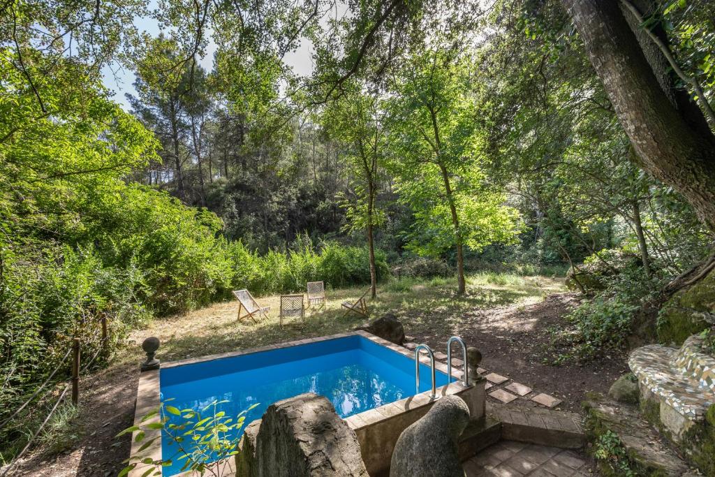 an outdoor hot tub in a garden with trees at Eco Masias Cal Ferran in El Bruc