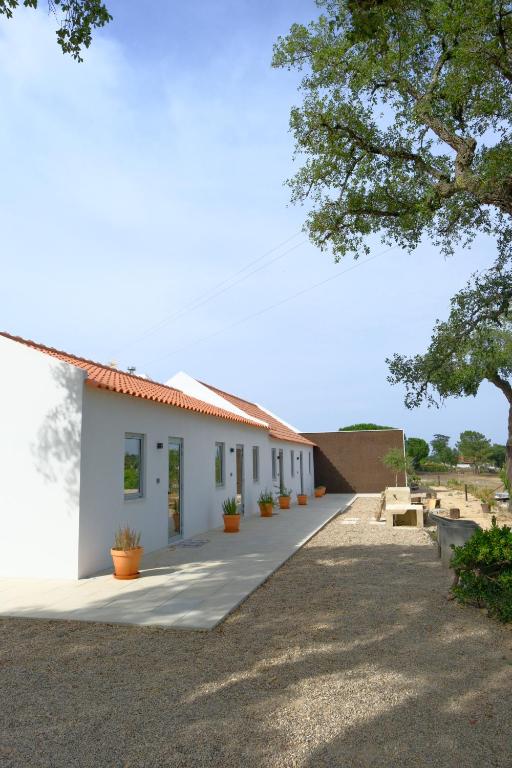 a white building with potted plants in front of it at Monte Garcia Nunes in Coruche