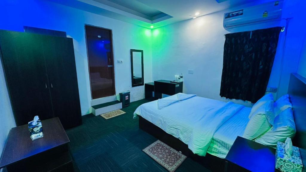 a bedroom with a bed and a blue room at Hotel Marvellen Inn Ltd in Dhaka