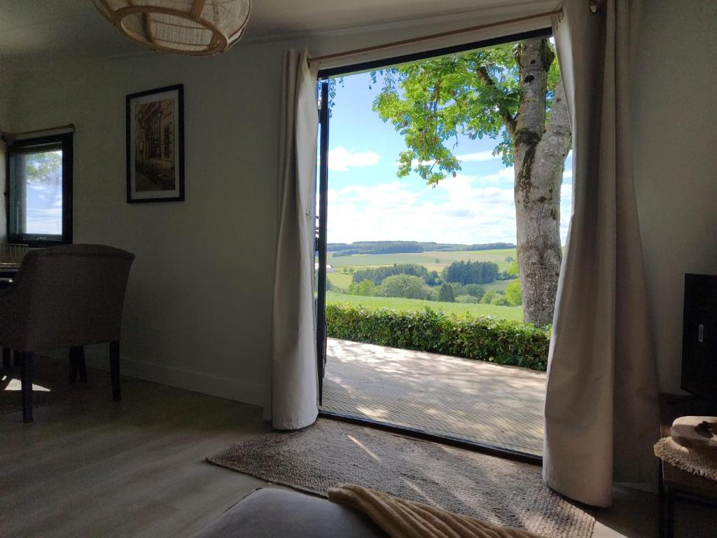 a sliding glass door with a view of a tree at A View for Two in Tarchamps