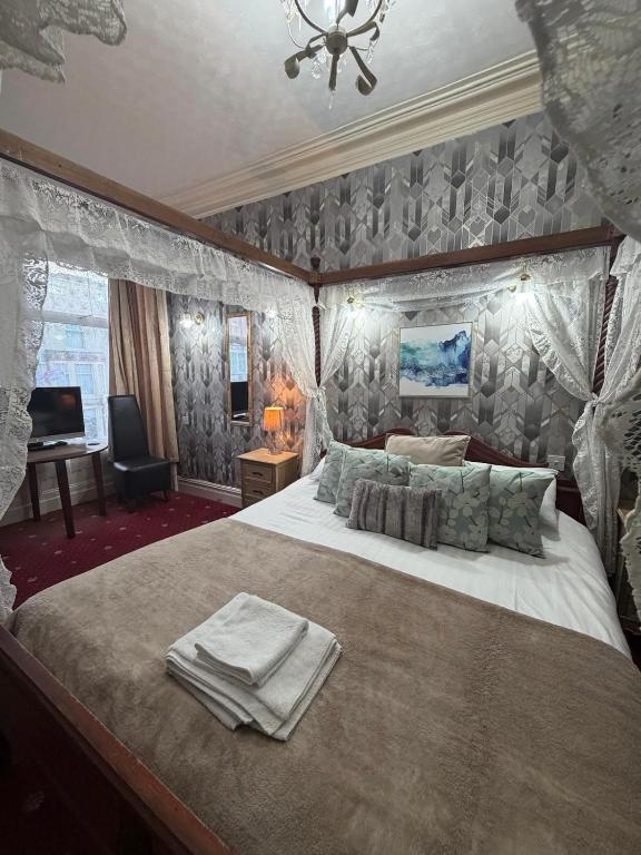 a bedroom with a large bed with towels on it at The Trafalgar in Blackpool