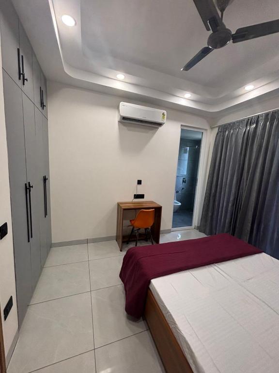 a bedroom with a bed and a desk and a window at Hotel Venezia Grand in Gurgaon
