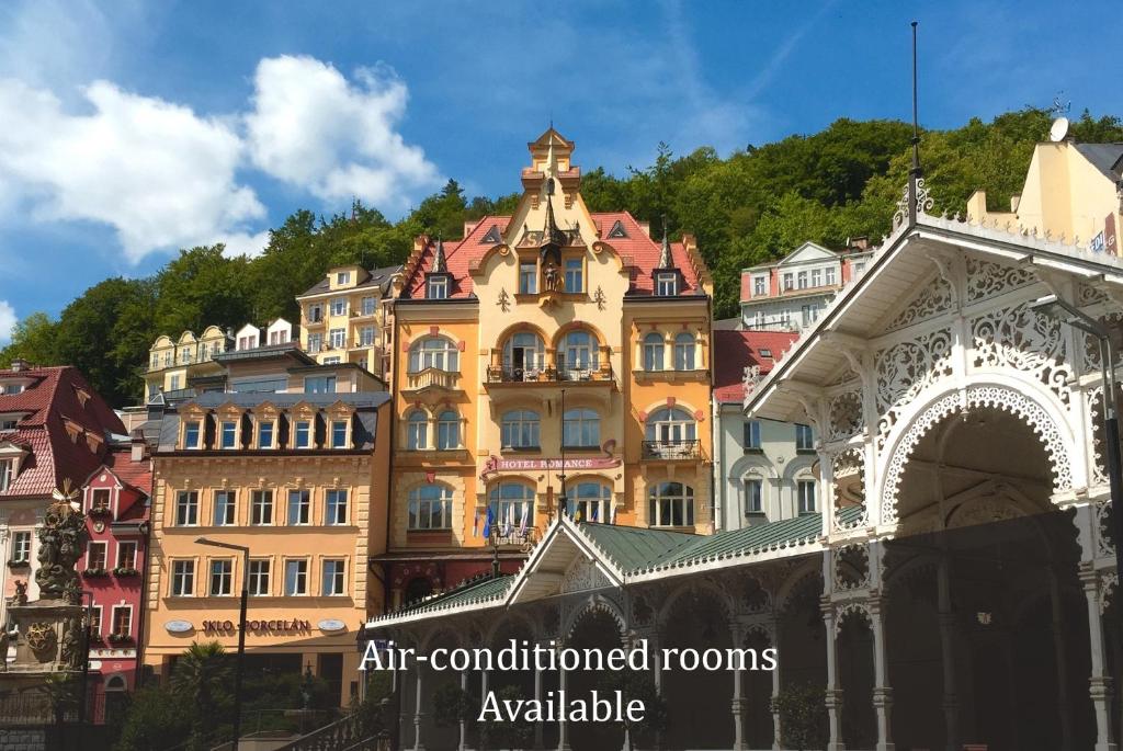 a large building in front of a group of buildings at Hotel Romance in Karlovy Vary