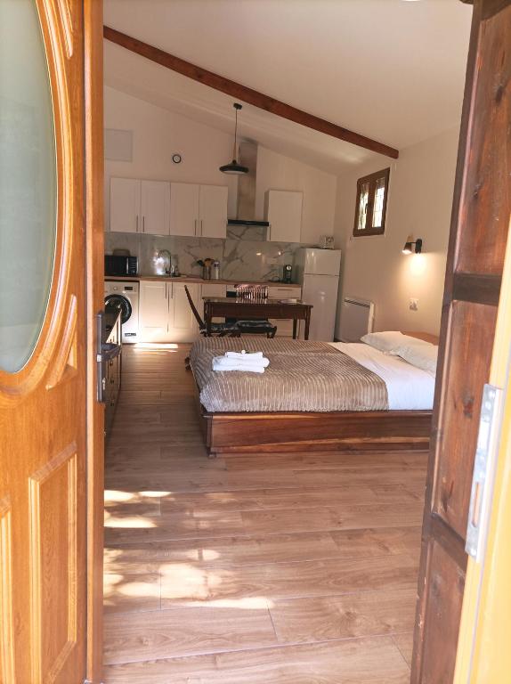a bedroom with a bed and a kitchen at Iris Garden Cottage in Saint-Germain-en-Laye