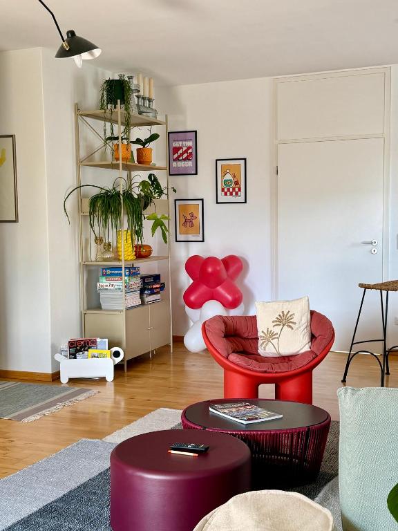 a living room with a red chair and a table at Apartment Luk - Design trifft Zuhause in Furth im Wald