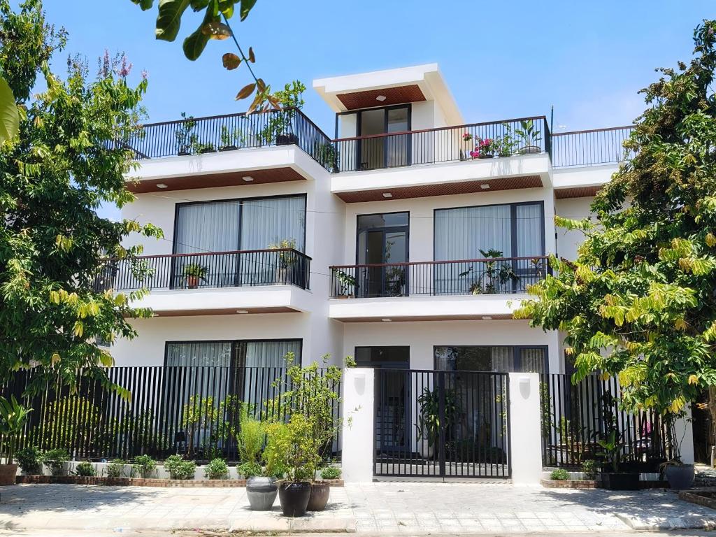 an apartment building with balconies and trees at Reka Homestay in Thôn Dương Phẩm