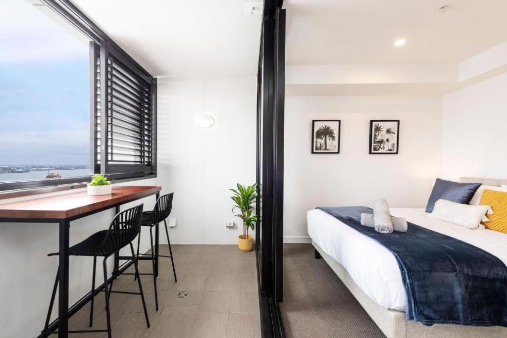 a bedroom with a bed and a desk and a window at Sunset on the Esplanade in Newcastle