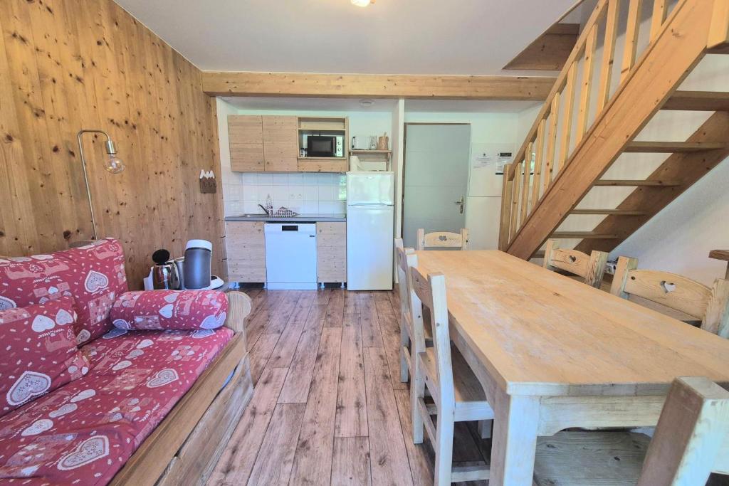 a kitchen and dining room with a table and a couch at Chalet MÖKI accès piscine sauna in Les Déserts