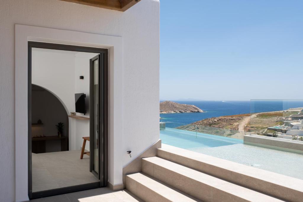 a doorway to a house with a view of the ocean at Ios Panoramic Sea view stylish suite with pool in Tzamaria