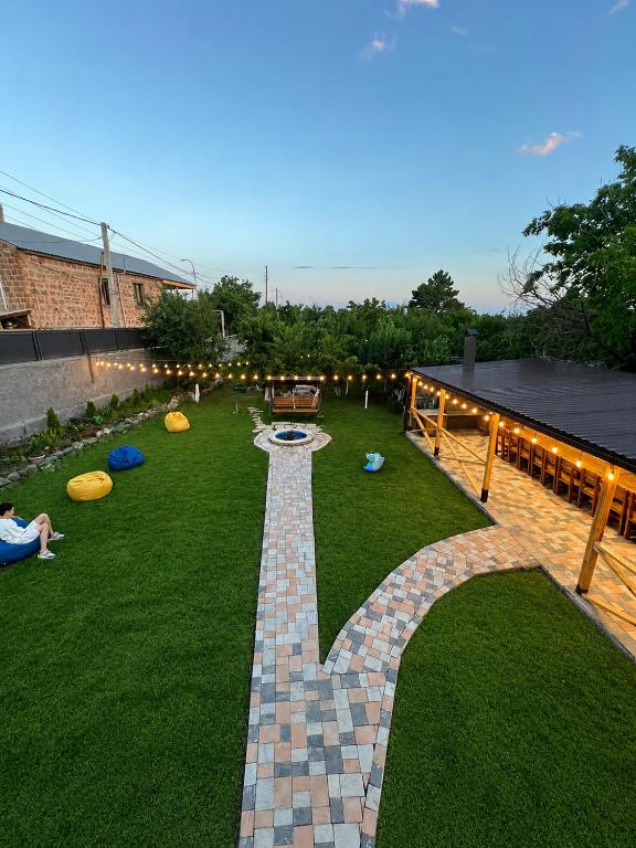 a garden with a brick pathway with frisbees on the grass at Гостевой дом in Oganavan