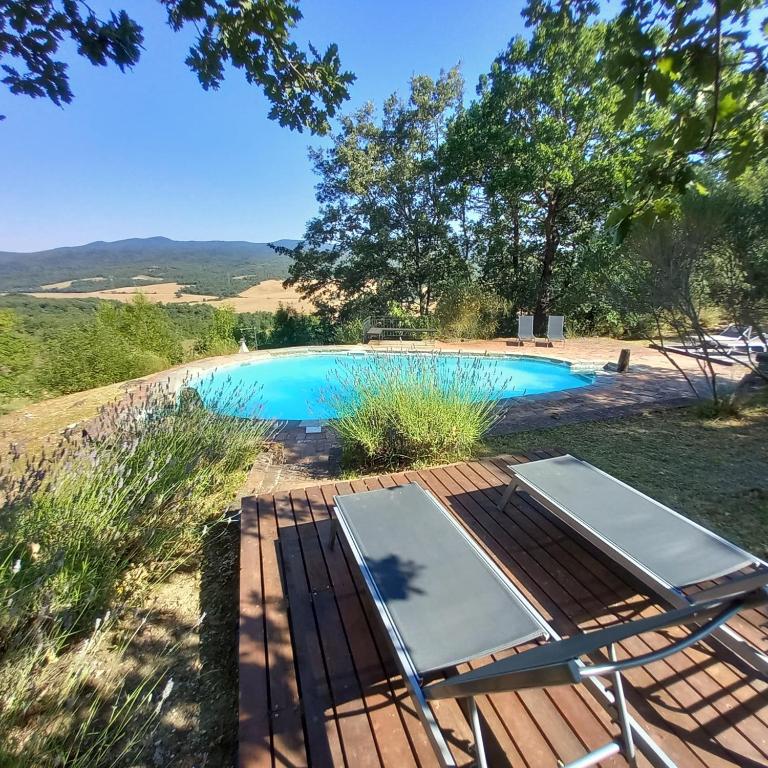 a pool with a table and chairs next to it at Agriturismo Timignano in Monteguidi