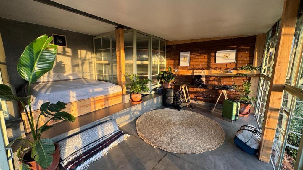 a bedroom with a bed and a large window at Embibi Mindfulness Cabins in Ngong