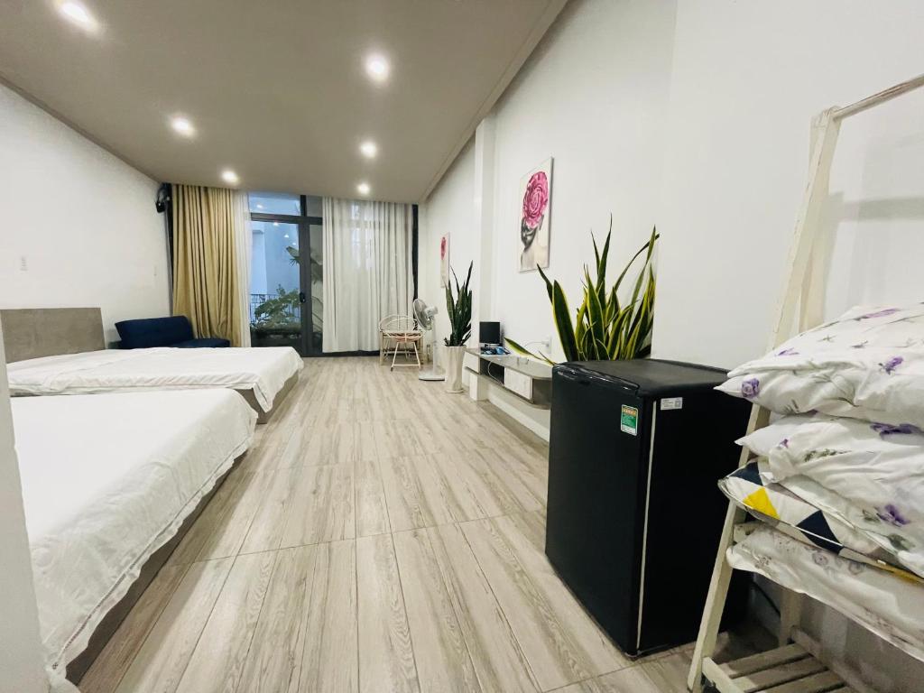 a bedroom with two beds and a desk in it at Coral Homestay Phan Rang in Kinh Dinh