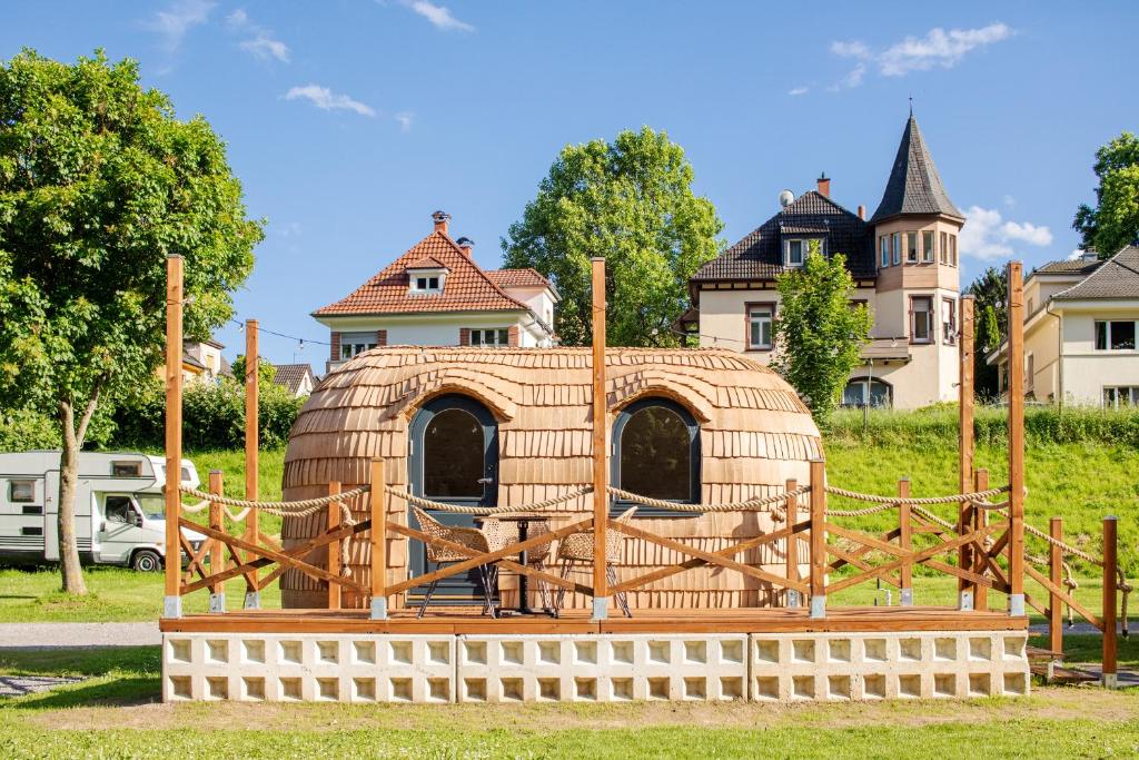 a wooden iguana in a yard with a house in the background at Camping Neckargemünd bei Heidelberg in Neckargemünd