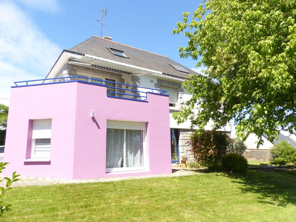 a pink house on a lawn with a tree at Chez Cathy in Réguiny