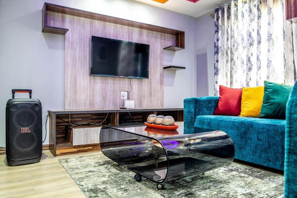 a living room with a tv and a blue couch at Red Pillar in Maseru