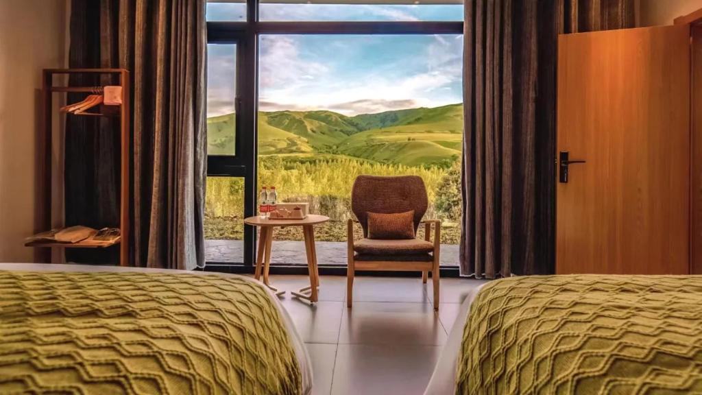 a hotel room with a bed and a chair and a window at Houshan Park House in Narat