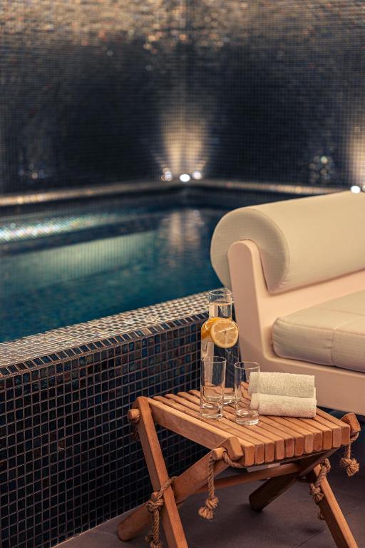 a couch and a table next to a swimming pool at Villas Foch Boutique Hotel & Spa Bordeaux in Bordeaux