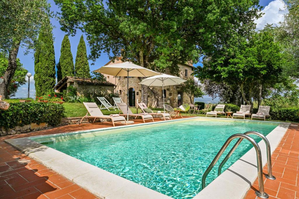 a swimming pool with chairs and umbrellas at Villa Caterina 8, Emma Villas in San Gimignano