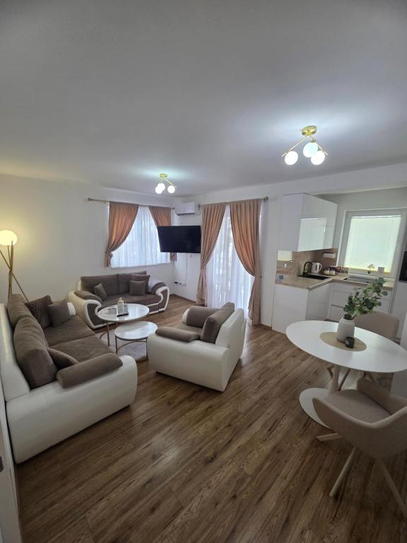 a living room with couches and tables and a kitchen at Golden Sky in Cazin