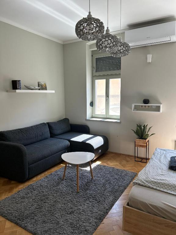 a living room with a couch and a table at Léna's apartman in Pécs