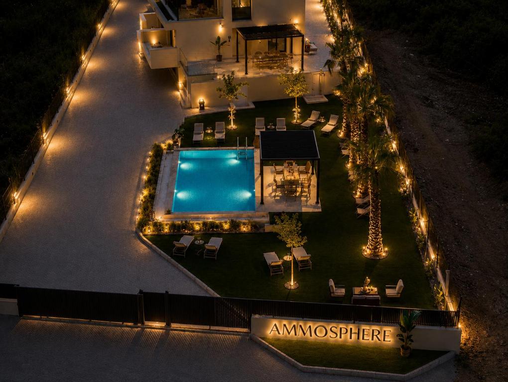 an overhead view of a house with a swimming pool at night at Ammosphere in Nea Peramos
