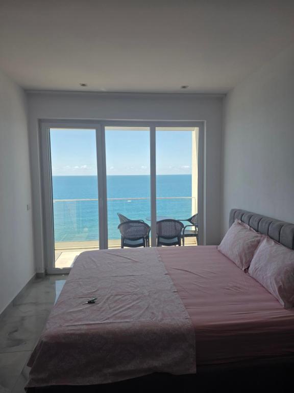 a bedroom with a bed and a view of the ocean at Amfora apartament Studio in Lezhë
