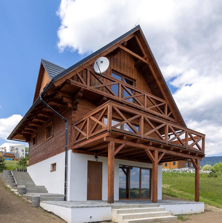 a house with a gambrel roof with a window at Chata Michala in Dolný Kubín
