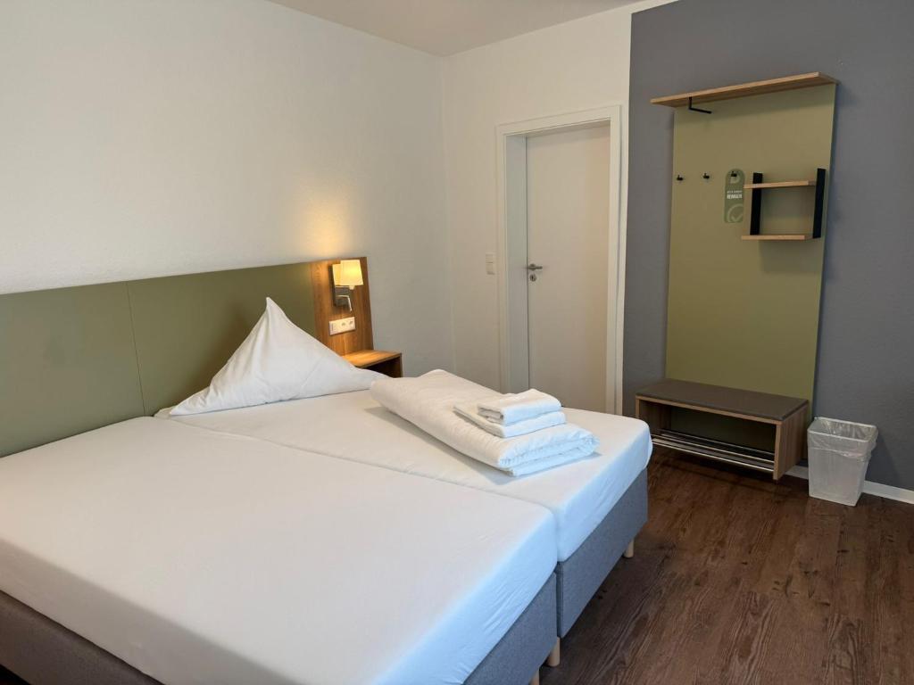 a bedroom with a white bed with towels on it at Ephesus am Weserwehr in Drakenburg