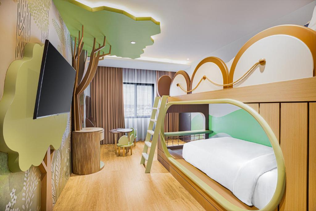 a childrens bedroom with a bunk bed and a tree mural at Fox Hotel Nagoya Batam in Nagoya
