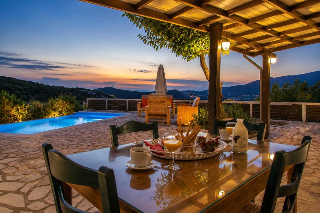 a dining table and chairs on a patio with a view at Villa Melody Private Pool Villa with Mountain Views in Fternón