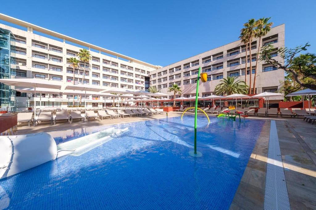 a large swimming pool with chairs and a hotel at Estival Park Almaris in La Pineda