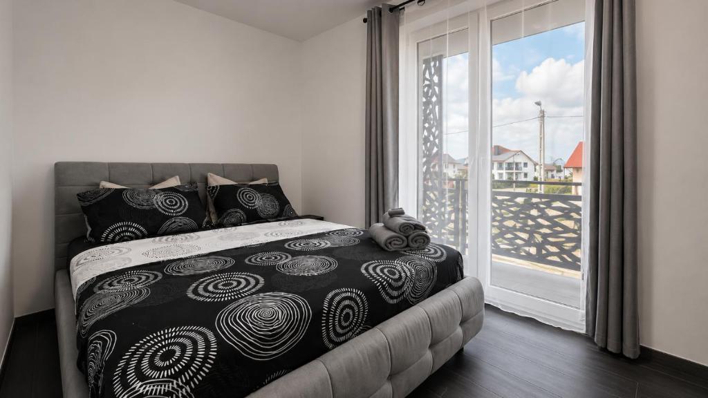 a bedroom with a bed and a large window at Art Suite - Private Parking in Oradea