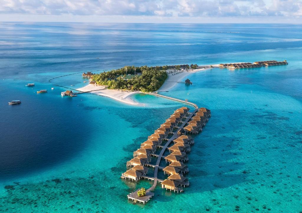 an island with a resort in the water at Constance Moofushi Maldives - All Inclusive in Himandhoo 