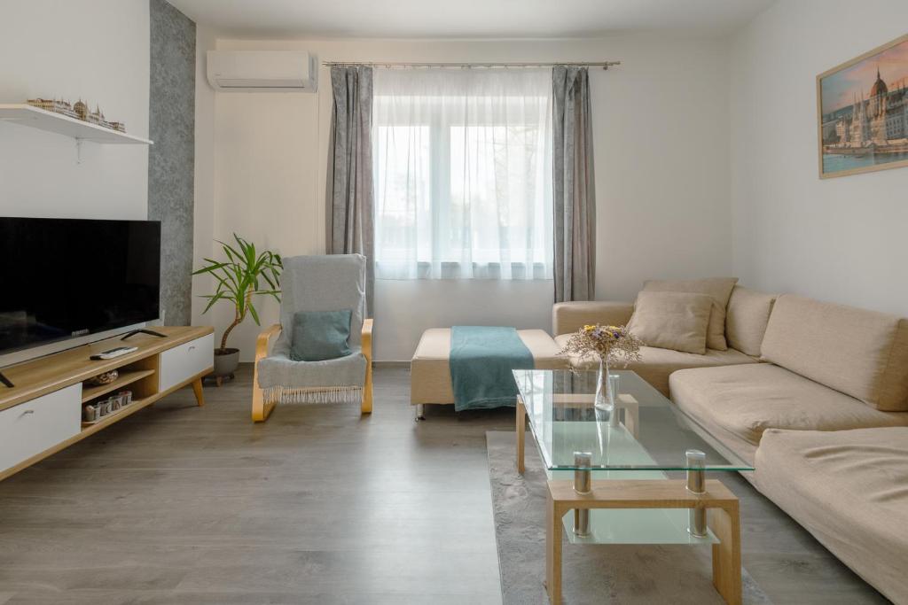 a living room with a couch and a tv at Terminal Garden Apartman in Budapest