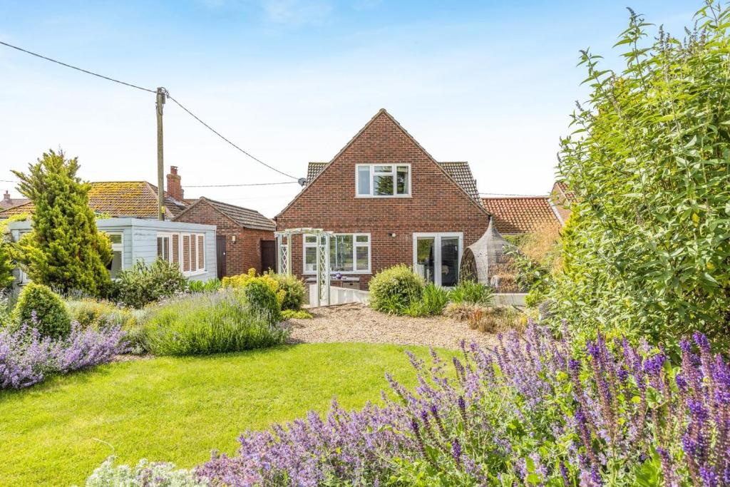 a house with a garden with purple flowers at 5 Bed in Bodham oc-2204 in Bodham