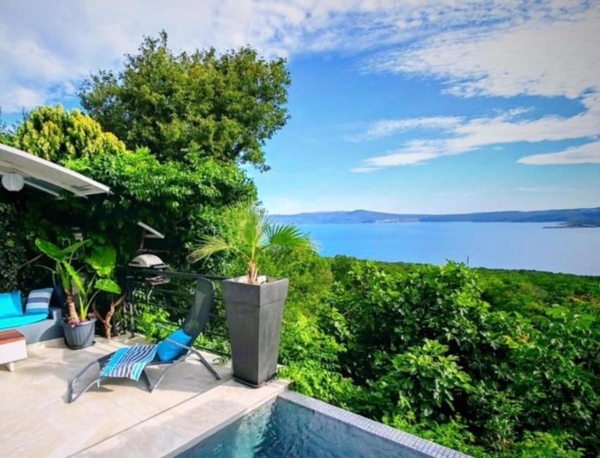 a pool with a chair and a view of the water at Art Gallery House with a small relaxing pool in Crikvenica