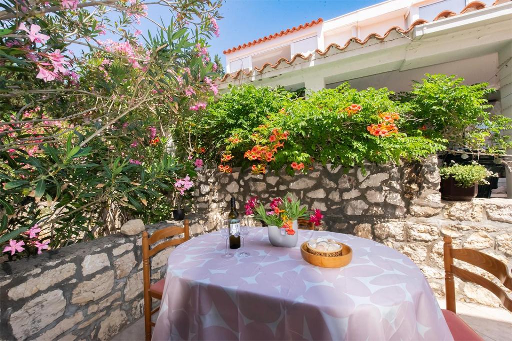 a table with a purple table cloth and flowers at Apartment Pasarela in Gajac