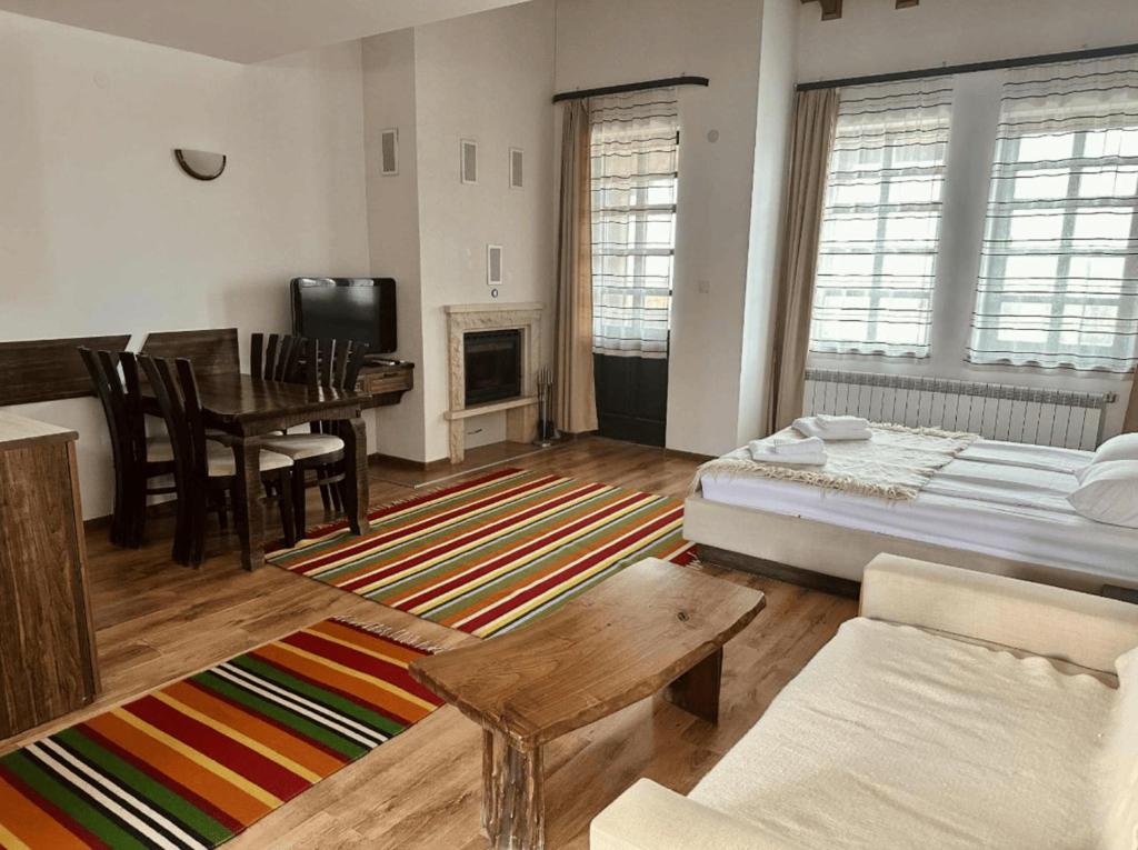 a living room with a bed and a dining room at Студио in Starosel