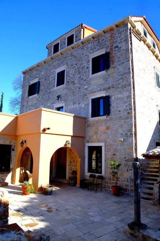 a large brick building with a patio in front of it at The Villa Vatikan in Trpanj