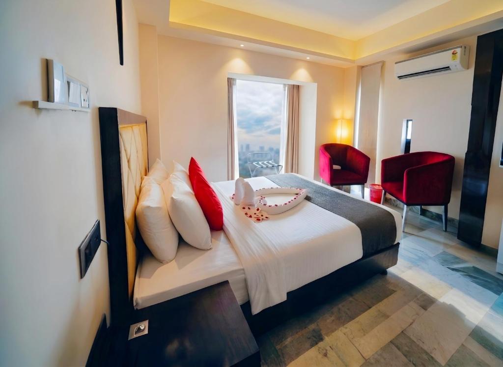 a bedroom with a large bed with red pillows at Elite Hotel Airport in Dhaka