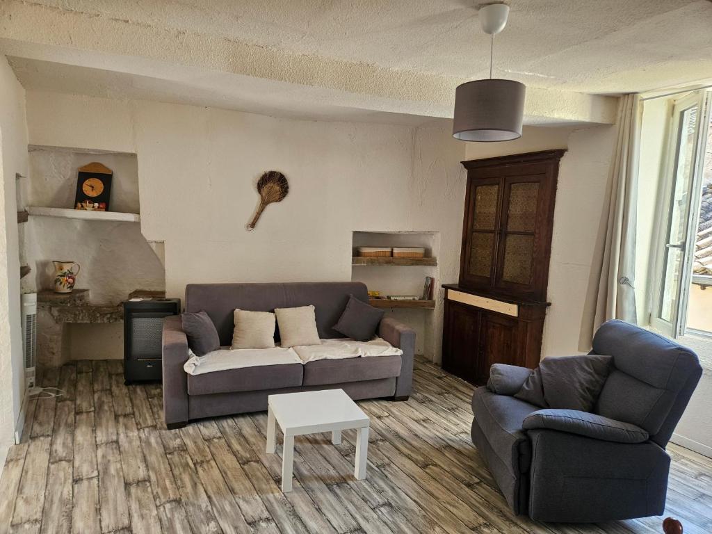 a living room with two couches and a table at Le papey in Molières-Cavaillac