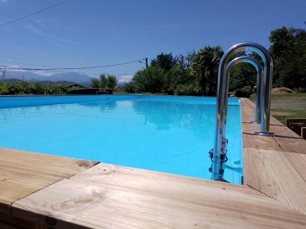 a swimming pool with a faucet next to a swimming pool at Pyrenees Vue Gite - Owl - Vues Fantastique, Petit-Déjeuner, Calme, Piscine, Parking - Brand New in Saint-Gaudens