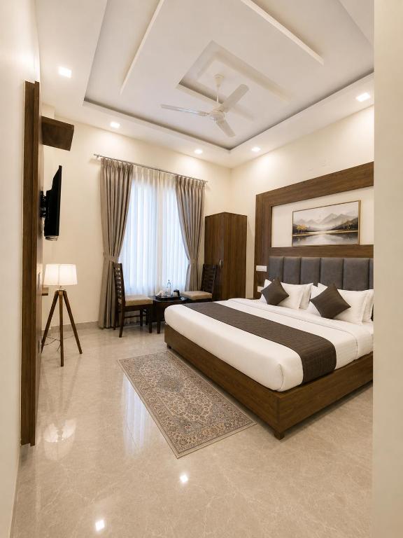 ein Schlafzimmer mit einem großen Bett und einem Schreibtisch in der Unterkunft Hotel Woodlark Square Zirakpur Chandigarh # Family Hotel # Property of the Year in Chandīgarh