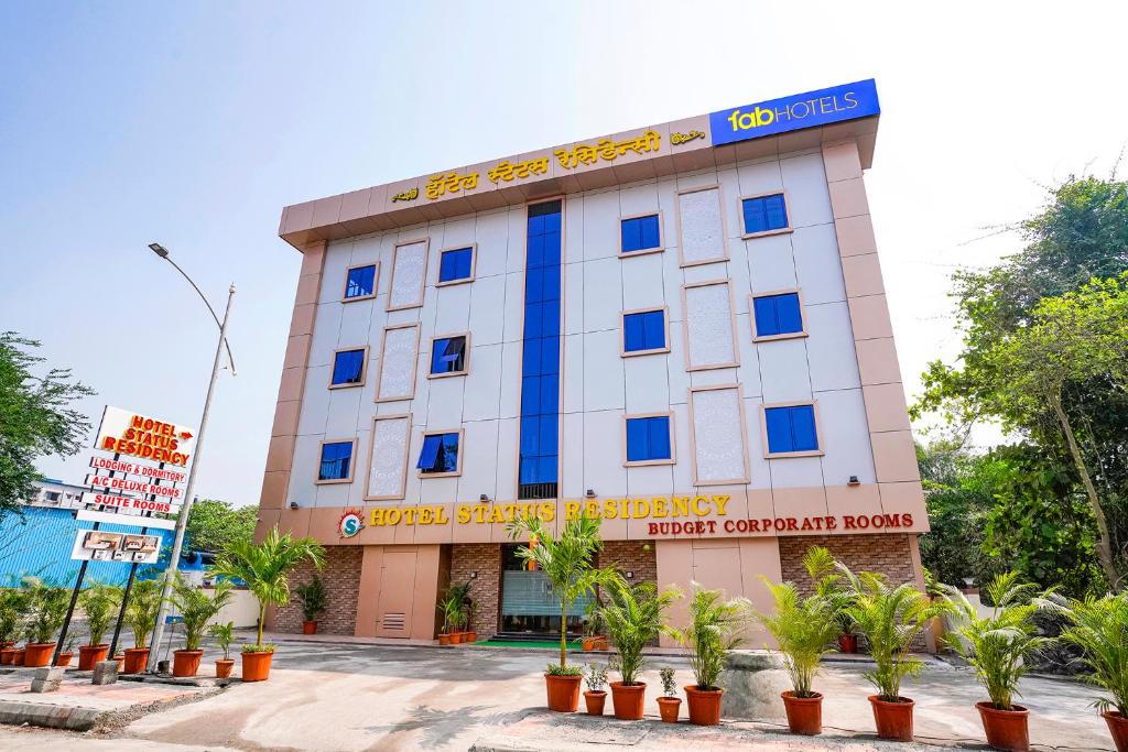 a building with blue windows and plants in front of it at FabHotel Status Residency in Mumbai