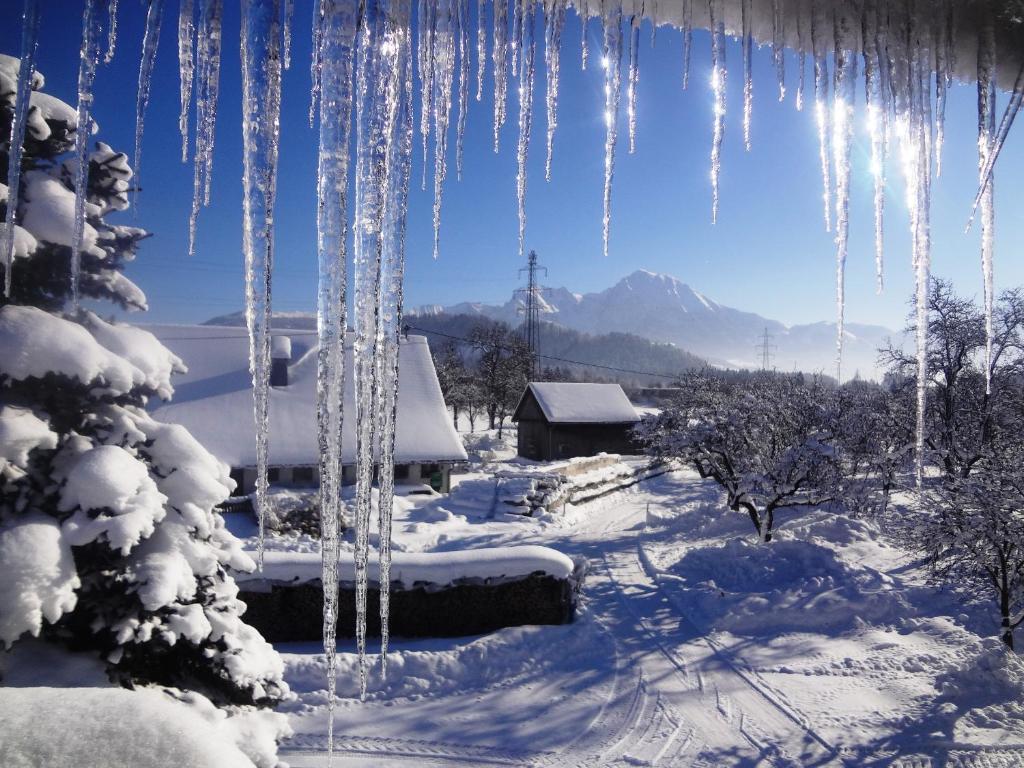 una escena de invierno con carámbanos colgando de una ventana en Ferienhof Kandler, en Rossleithen