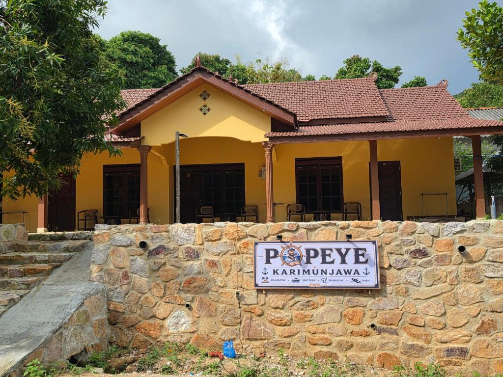 a sign on a wall in front of a house at Popeye Karimunjawa in Karimunjawa