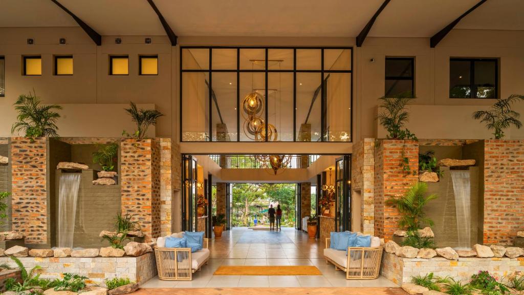 a lobby of a building with blue chairs at Waterfalls Lodge in Victoria Falls