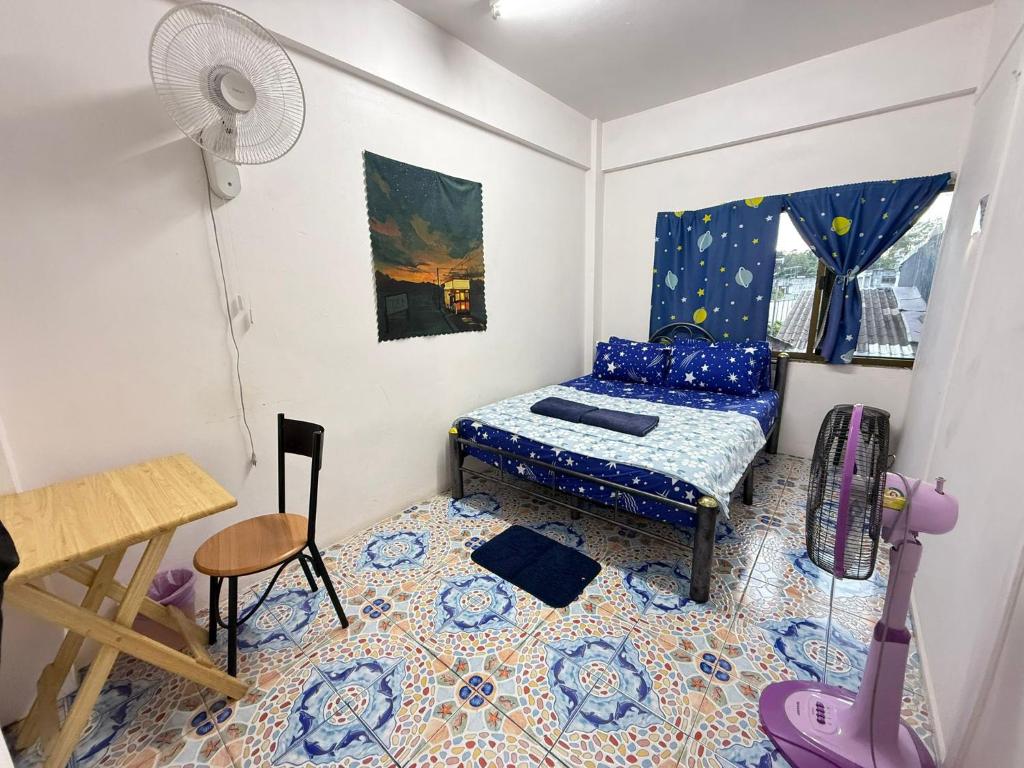 a small room with a bed and a table at Madam Guesthouse in Krabi